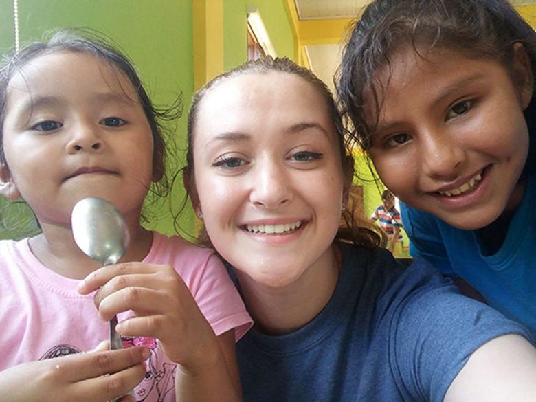 A Penn State Altoona Enactus student with children in Bolivia